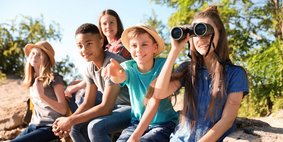 Kinder mit Fernglas Kinder machen einen Ausflug in die Natur und schauen durch ein Fernglas