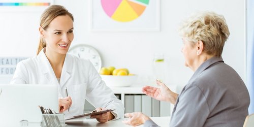 Lächelnde Ärztin berät Frau Lächelnde Ärztin berät Frau