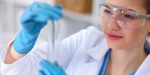 Hygiene und Gesundheitsschutz Eine Frau untersucht eine Probe in einem Reagenzglas