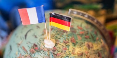 Frankreich- und Deutschlandflagge Frankreich- und Deutschlandflagge stecken in Miniaturform in einem Globus