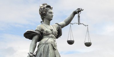 Justitia, Göttin der Gerechtigkeit mit Waage in der linken und Richtschwert in der rechten Hand. 