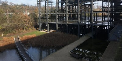 Alte Industriehalle am Wasser mit einer Brücke davor